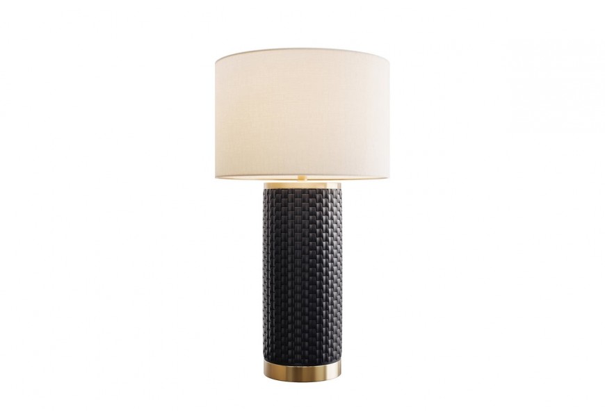 Designová glamour černobílá lampa Draconia s válcovitou nohou s geometrickým obdélníkovým reliéfem připomínajícím šupiny a hladkým kulatým stínítkem z textilu v bílé barvě s kovovými detaily a konstrukcí ve zlaté barvě