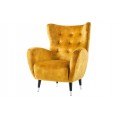 Designové retro glamour sametové žluté křeslo ušák Bolte s vysokou zádovou opěrkou s prodlouženými rohy s prošíváním s kulatými knoflíky se zaoblenými bočními opěrkami a šikmými černými nožičkami se stříbrným detailem