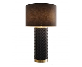 Designová art deco keramická stolní lampa Draconia s černým kulatým textilním stínítkem a válcovitou nohou s geometrickým obdélníkovým reliéfním vzorem se zlatými kovovými detaily