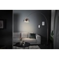 Moderní oblouková stojací lampa s chromovým kovovým stínítkem a černým podstavcem v minimalistickém stylu.