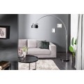 Moderní oblouková stojanová lampa s chromovým kovovým stínítkem v lesklém provedení a černým podstavcem vhodná do minimalistického interiéru.