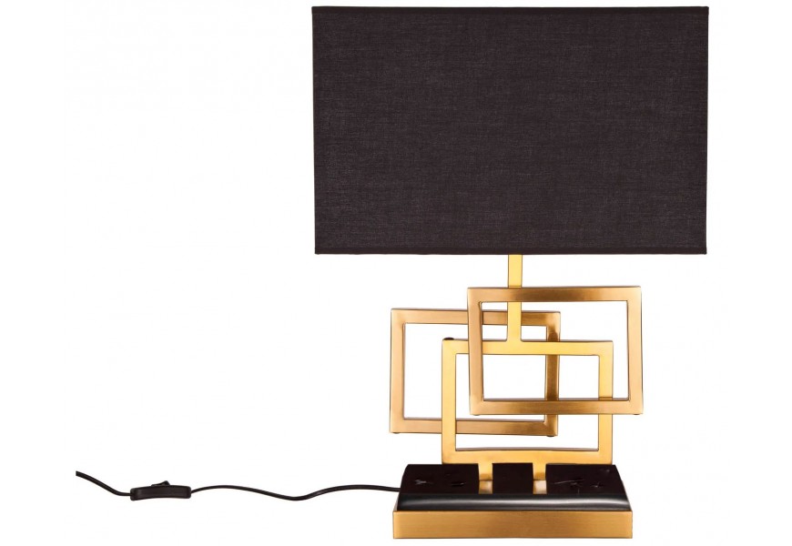 Stolní lampa s černým obdélníkovým textilním stínítkem a zlatou kovovou konstrukcí z propojených geometrických rámů