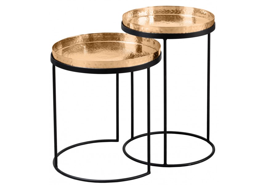 Set art-deco příručních stolků s kulatými kovovými deskami v teplé zlaté barvě s jemnou kladívkovou strukturou a černými kovovými podstavami s obloukovým zakončením