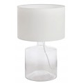 Moderní stolní lampa s bílým válcovým textilním stínítkem a průhledným skleněným podstavcem ve tvaru láhve s viditelným kabelem uvnitř