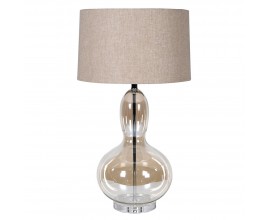 Designová glamour stolní lampa Kayla s nohou z průhledného skla s hnědým tónováním se zaoblenou siluetou ve tvaru hrušky s kulatým béžovým lněným stínítkem a kovovou konstrukcí v lesklém chromovém provedení