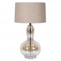 Designová glamour stolní lampa Kayla s nohou z průhledného skla s hnědým tónováním se zaoblenou siluetou ve tvaru hrušky s kulatým béžovým lněným stínítkem a kovovou konstrukcí v lesklém chromovém provedení