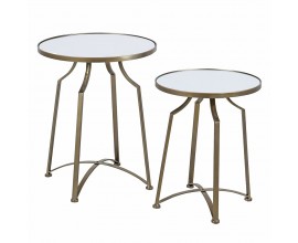 Designová zrcadlová glamour sada dvou příručních stolků Liven s kulatými vrchními deskami se čtyřmi prohnutými nožičkami s příčkou ve tvaru x z kovu ve zlaté barvě s patinou s matným povrchem