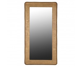Luxusní industriální zrcadlo Gabor s vysokým širokým obdélníkovým rámem se zaoblenými rohy s nerovnou strukturou připomínající beton ve zlaté barvě