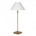 Luxusní glamour stolní lampa Tarkten se štíhlou zlatou kovovou nohou se čtvercovou podstavou a kulatým dole rozšířeným stínítkem ze lnu v bílé barvě Luxusní glamour stolní lampa Tarkten se štíhlou zlatou kovovou nohou se čtvercovou podstavou a kulatým dole rozšířeným stínítkem ze lnu v bílé barvě