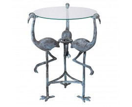 Designový příruční stolek Flamingo Blue v kulatém tvaru se skleněnou průhlednou deskou a kovovou podstavou ve tvaru tří plameňáků s modře šedou patinou