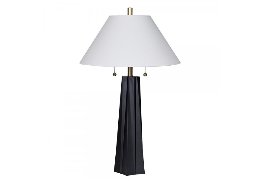 Moderní glamour stolní lampa Villara s designovou skulpturální podstavou z akrylu v černé barvě se zlatou kovovou konstrukcí a bílým širokým lněným stínítkem kuželovitého tvaru