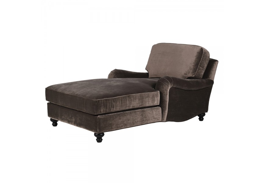 Luxusní vintage glamour lenoška Ingren s čalouněním a potahem ze sametu v šedém odstínu taupě s nízkými bočními opěrkami a prodlouženým sedadlem s kulatými nožičkami v černé barvě s vyřezávaným profilem