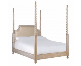 Luxusní venkovská masivní manželská postel Boia s rámem z recyklovaného dřeva ve světle hnědé barvě na nízkých kulatých nožičkách se čtyřmi vysokými sloupky s vyřezávaným designem kuliček a čelem s čalouněním ve světle béžové barvě