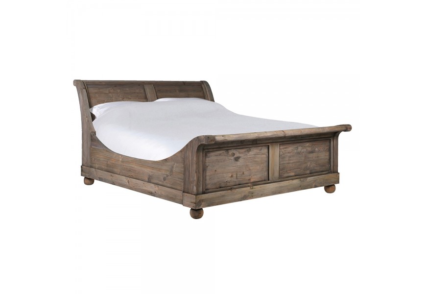 Luxusní vintage manželská postel Helmar z recyklovaného masivního dřeva v naturální hnědé barvě s přiznanou strukturou letokruhů s jemnou patinou s kulatými nožičkami se zvýšenou patou a čelem s vyhnutou vrchní částí