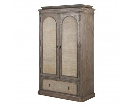 Luxusní venkovská masivní šatní skříň Rickon s dvojitými dveřmi a šuplíkem s ratanovým výpletem s klenutým designem z masivního dřeva mindi v naturální hnědé barvě s šedou patinou