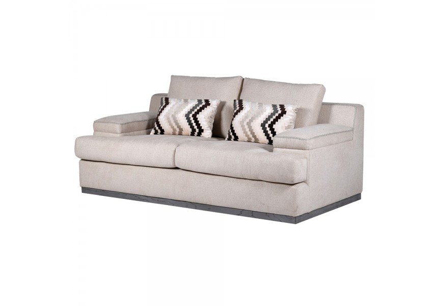 Luxusní retro béžová sedačka Miranda pro dvě osoby s plnou podstavou s šedým dřevěným lemem s hranatými bočními a zádovými opěrkami a dvěma akcentovými polštáři s chevronovým vzorem s černé a zemitých hnědých barvách