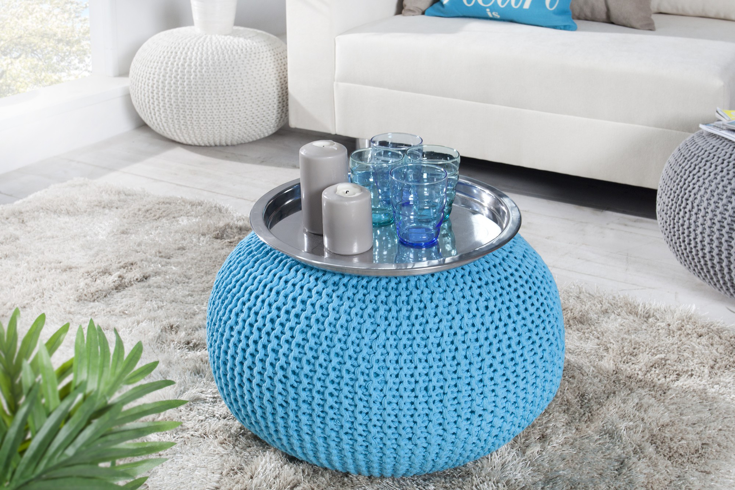 Modrá kulatá taburetka typu puf s pleteným designem a stříbrným podnosem